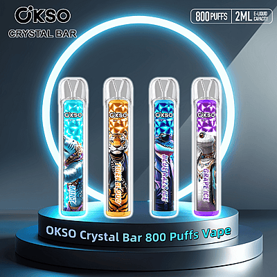 Exposição de produtos dos vapes OKSO Crystal Bar com capacidade para 800 tragadas, apresentando quatro designs: Mint, Tiger Blood, Blue Razz Ice e Grape Ice, exibidos em um pódio futurista com destaque em anel brilhante.