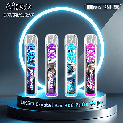 Quatro canetas vaporizadoras OKSO Crystal Bar exibidas em um suporte circular brilhante, apresentando designs e sabores vibrantes, como Blue Razz Ice, Grape Ice, Minty e Strawberry Ice, com texto destacado indicando 800 tragadas e capacidade de e-líquido de 2 ml.